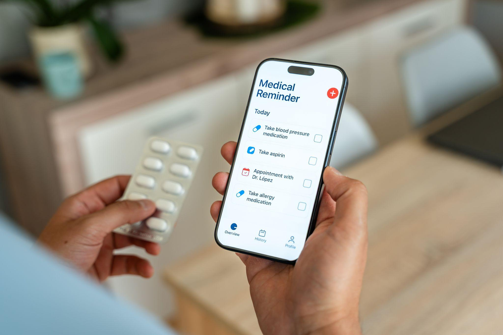 A person holds pills and a phone showing a medication reminder app with today’s medicines and a doctor’s appointment.